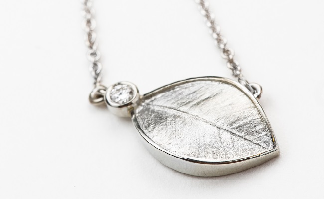 Leaf pendant in white gold, with bezel-set diamond accent – also available in yellow gold
