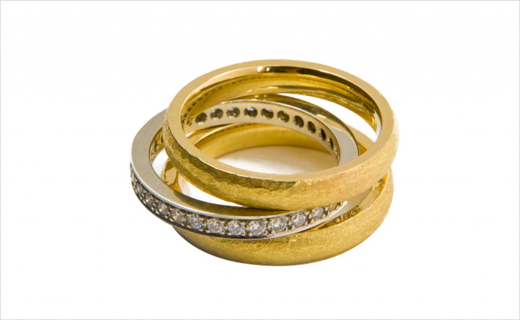 Stacking hammered bands in 18K yellow gold, matched with a pavé diamond band